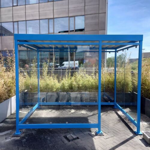 Overkapping voor automaten model Myla 31 Blauw gecoate rookoverkapping Myla 3x2m met inloopopening op betonpoeren geplaatst op parkeerterrein